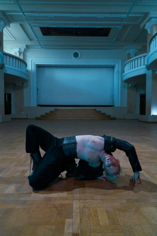 a man wearing all black performing on a floor