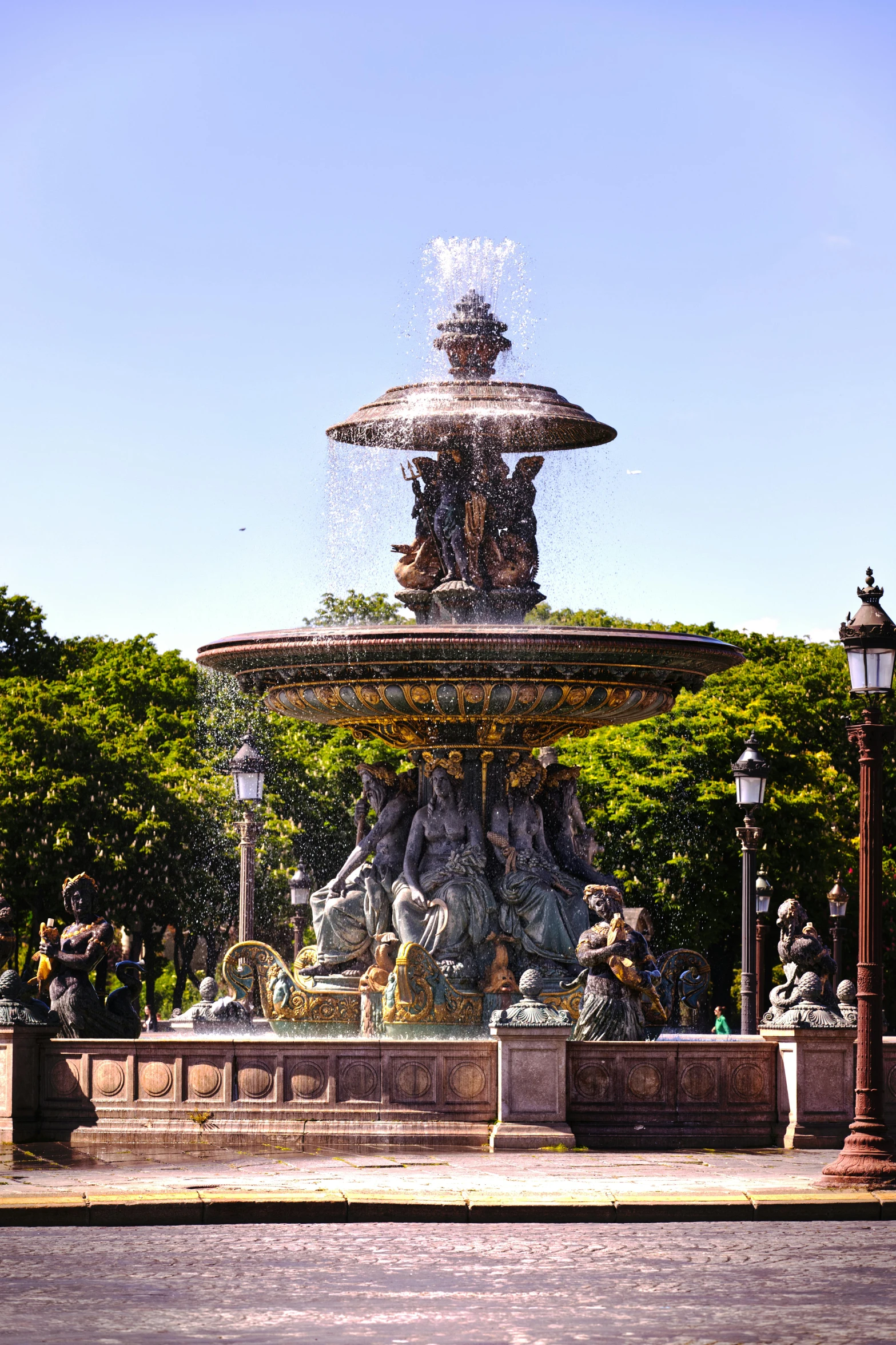 a fountain with a large head is situated on the sidewalk