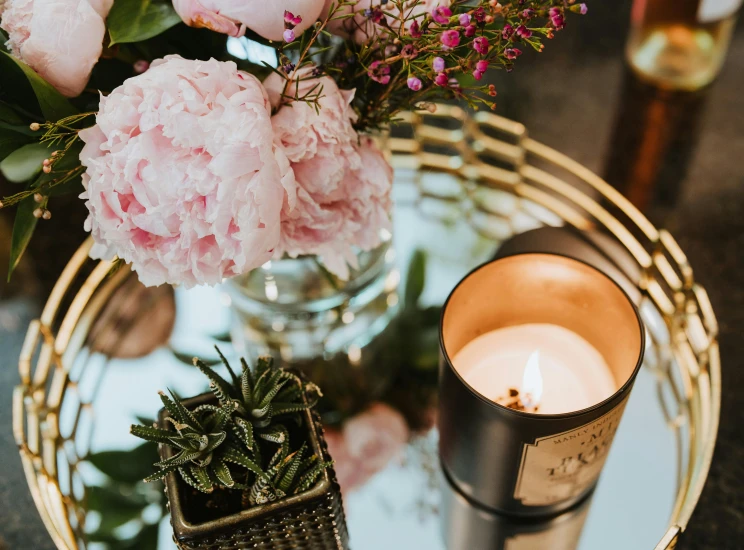 a bouquet of flowers and some candles on a glass table