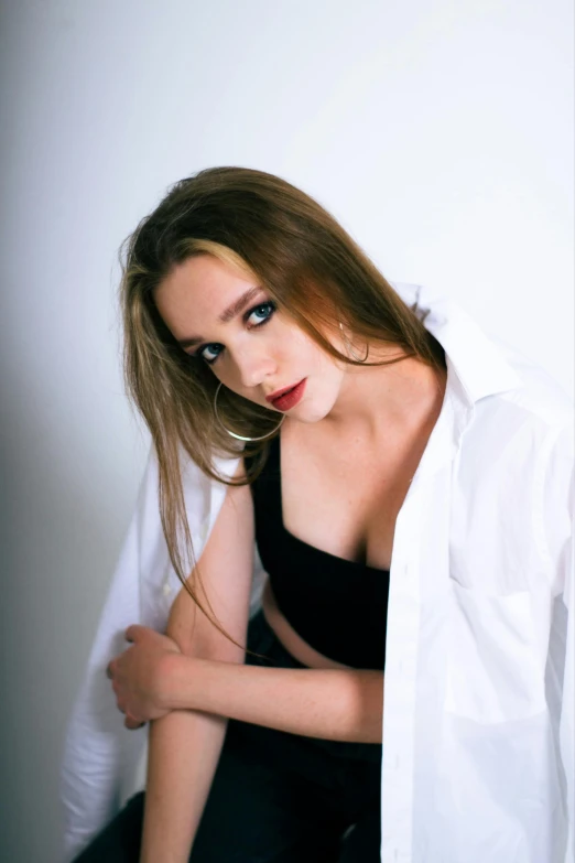 a woman in black and white shirt sitting on a stool