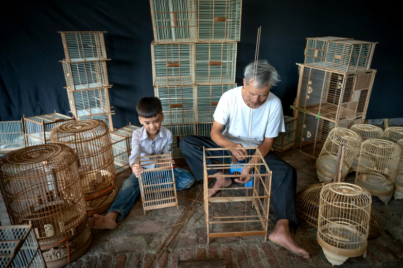 two men are making crafts out of birds cages