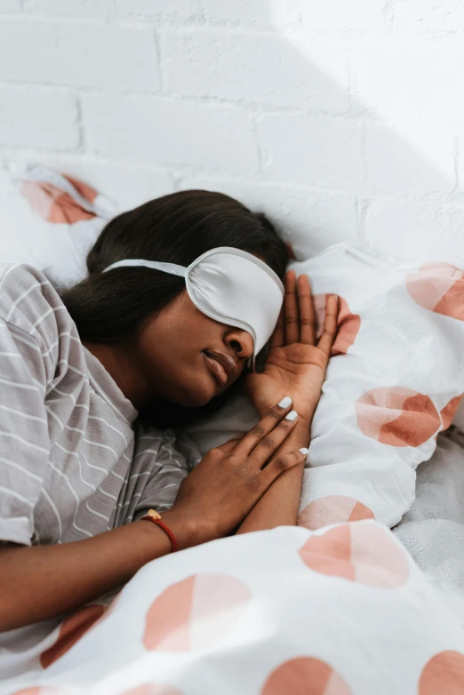 a woman with blindfold and eye mask in bed