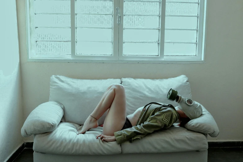 a woman laying on a white couch with her arms on a purse