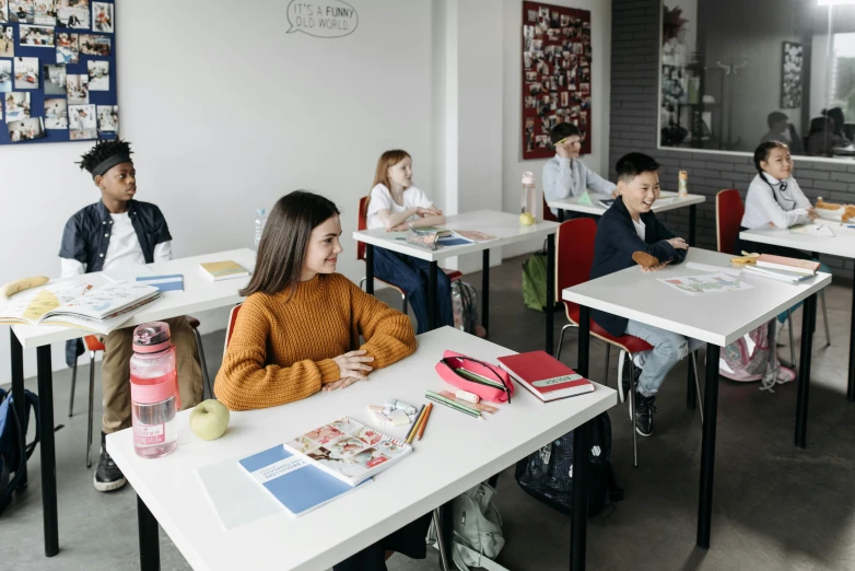 a group of children sitting at desks with books