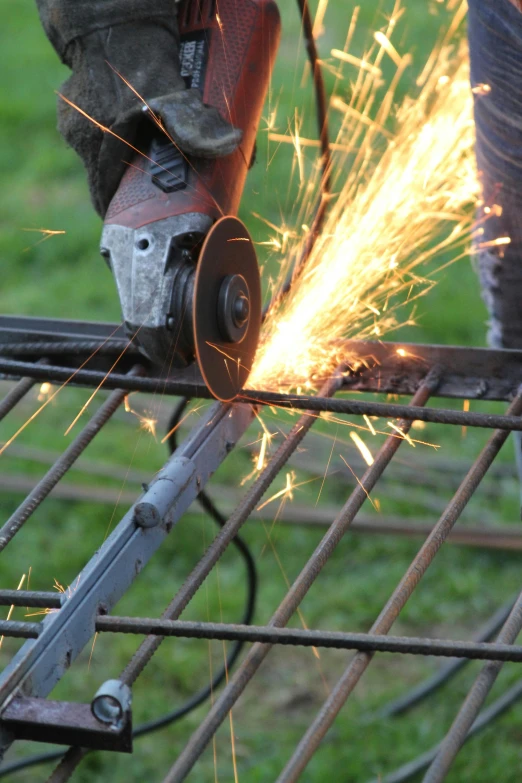 a worker grinding metal bars with a grinder