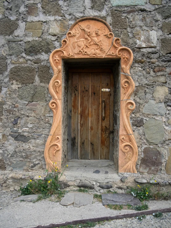 an old door with a carved niche next to it