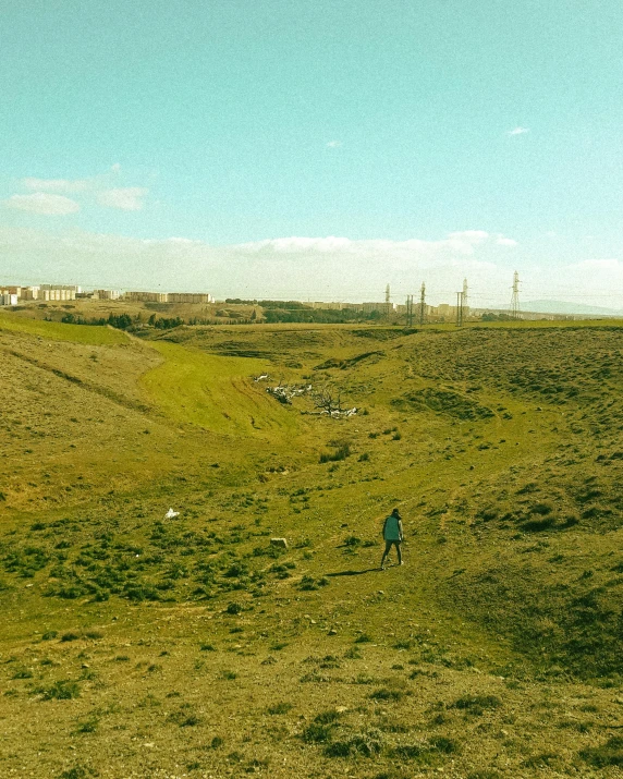 a man in a grassy field in the distance