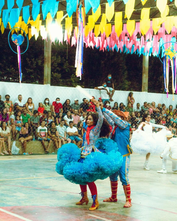 two performers perform a dance during a large audience