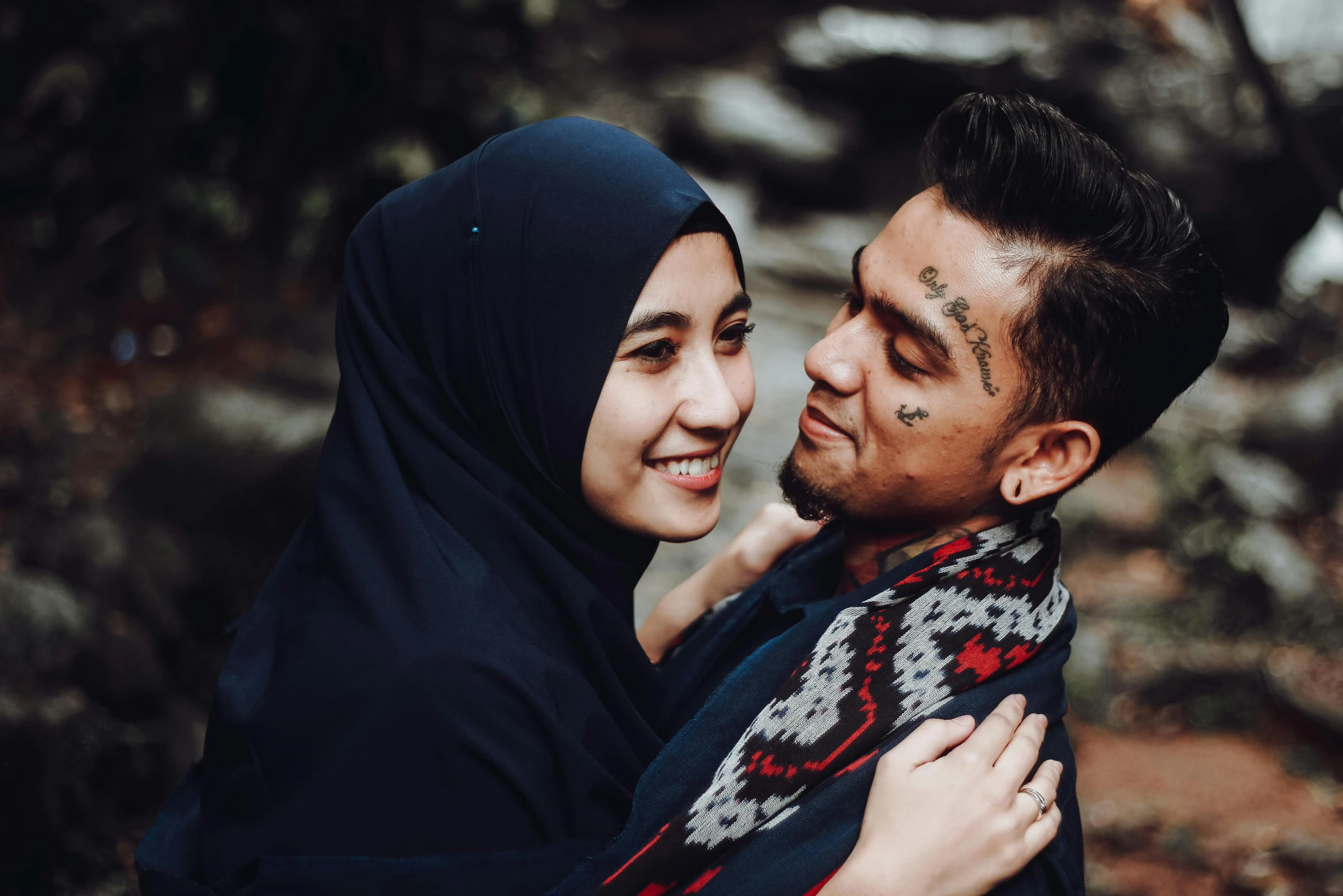 man hugging his wife with tattoos on their bodies