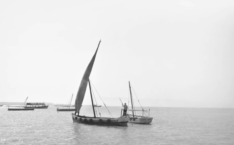 a sail boat and some boats on the water