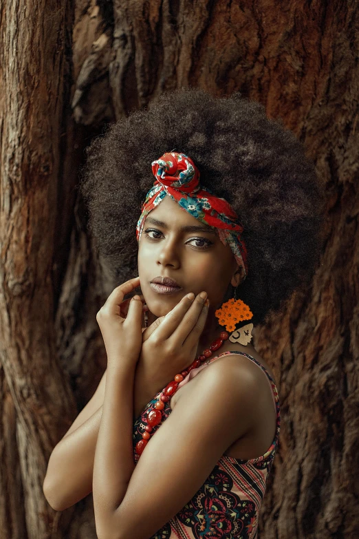 woman with large headpiece standing near tree