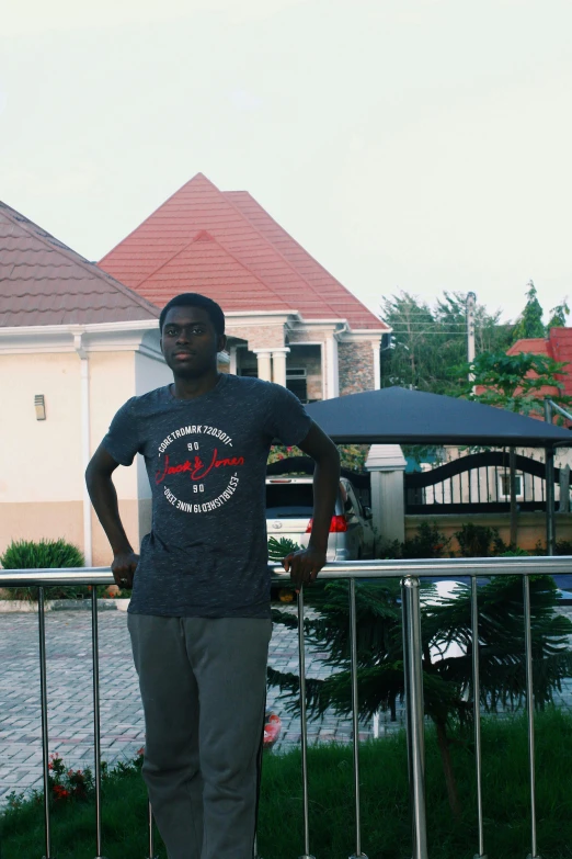 a young man is posing for the camera in front of the house