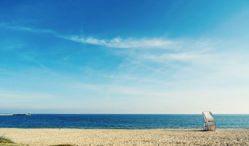 a white umbrella sitting on top of a sandy beach