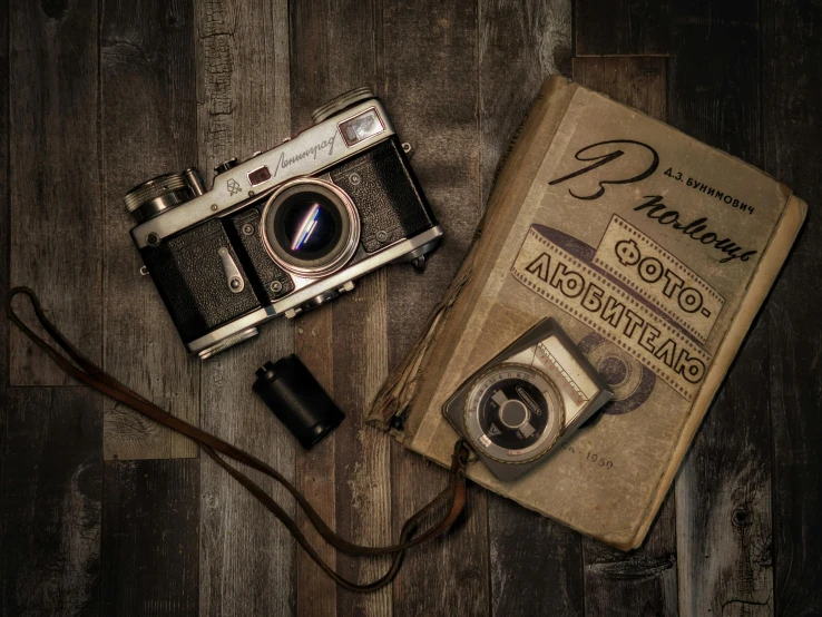 an old book with two small cameras and a strap