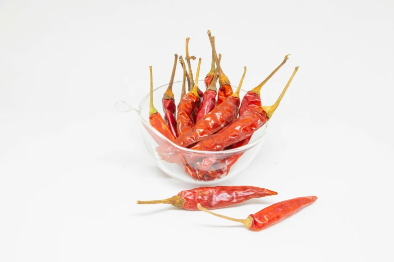 a glass bowl containing dried red  chili peppers