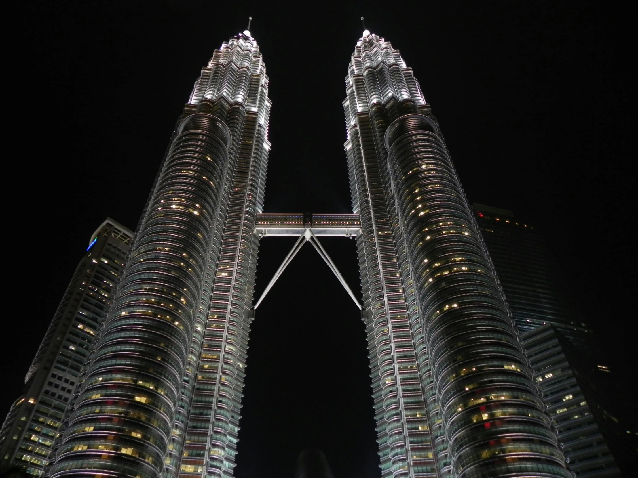 looking up at some tall buildings that are lit up at night