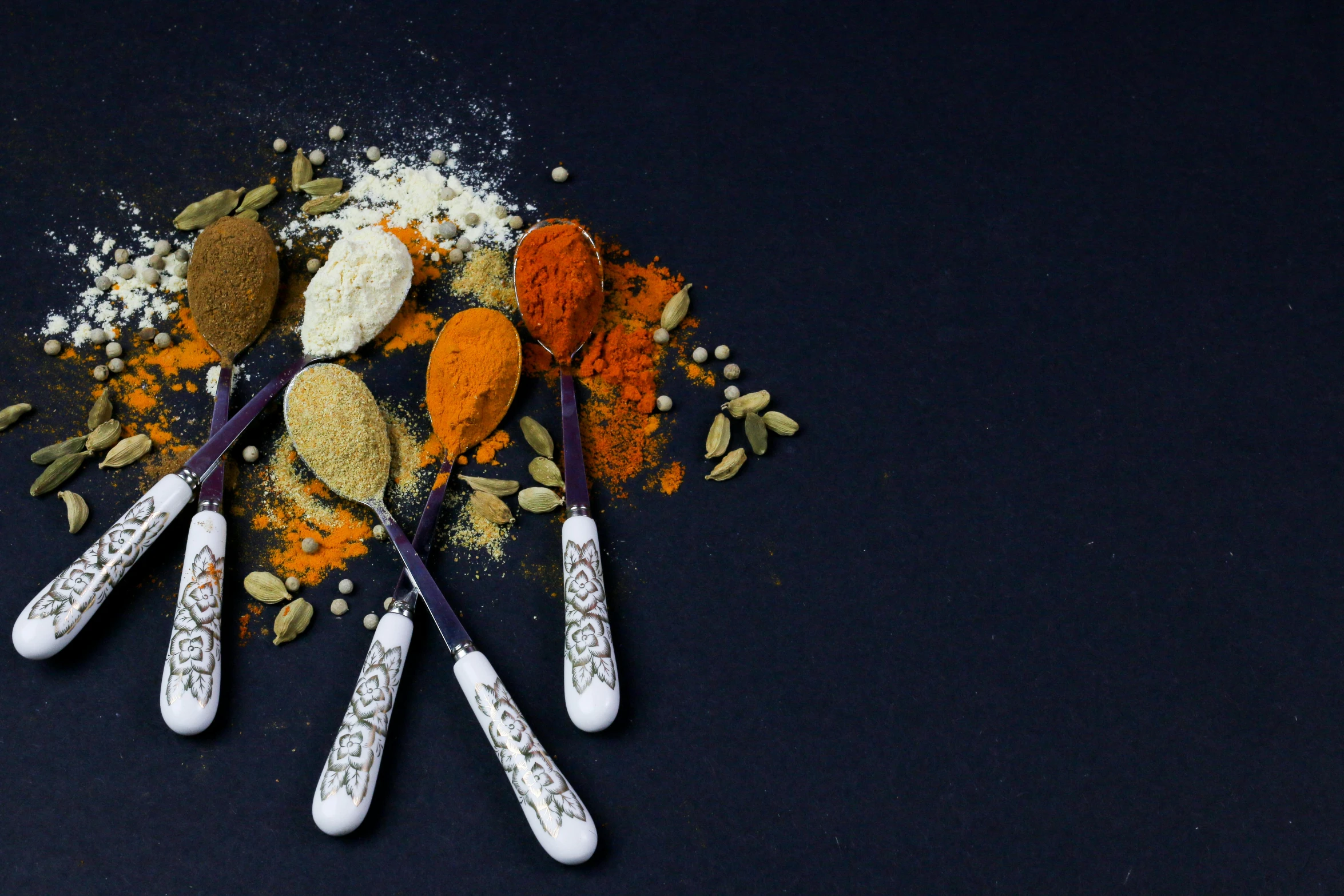 a pile of different types of spoons on a blue surface