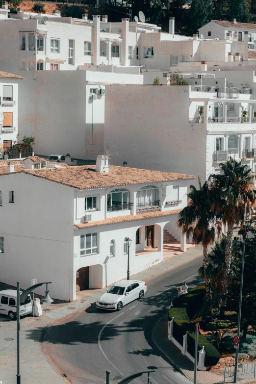 an urban area with a street, lots of buildings and white cars