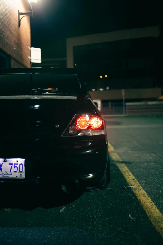 the tail lights of a parked black car