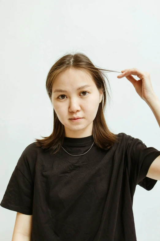 a beautiful young woman adjusting her hair with a clip