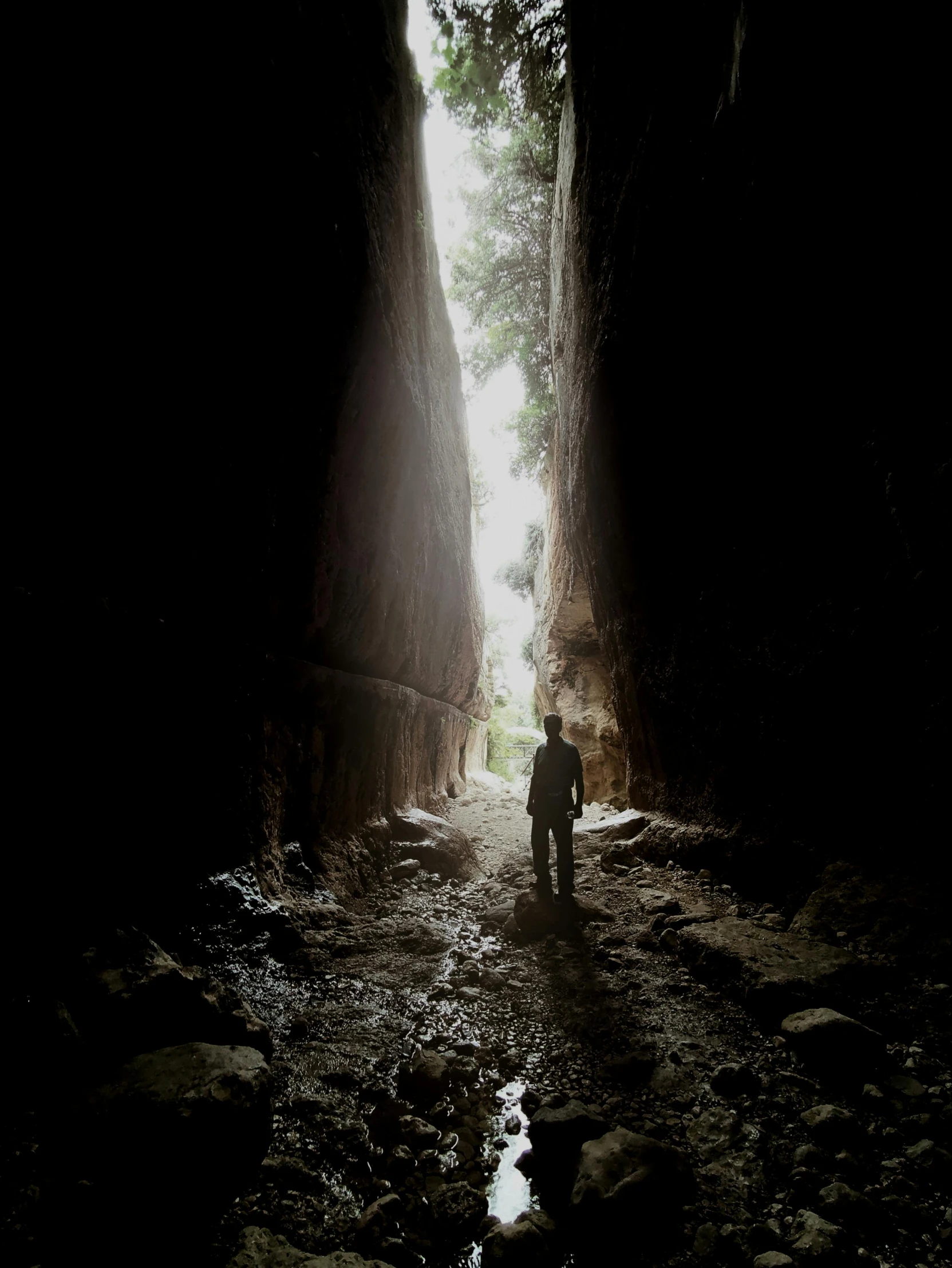 a man standing inside the entrance to a dark tunnel