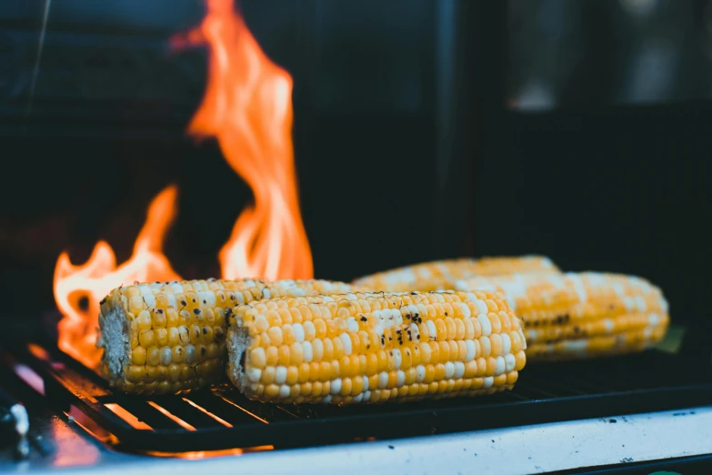 corn on the cob on the grill as flame approaches