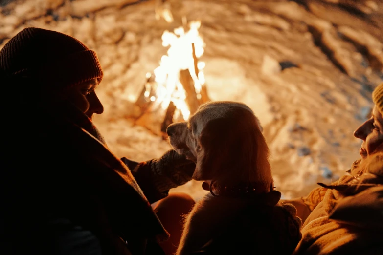 two people standing outside by a fire at night