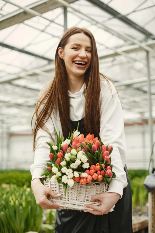 a young woman holds a basket of flowers