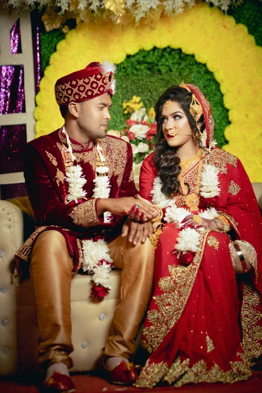 bride and groom sitting side by side on sofa posing for a portrait