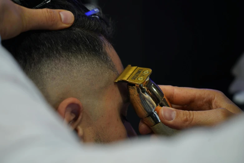 man getting his hair cut with an old cell phone