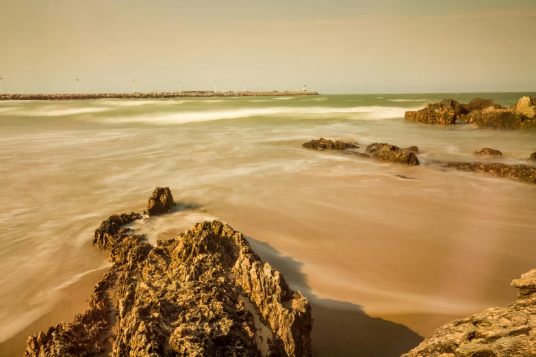 a large body of water near rocks and some waves