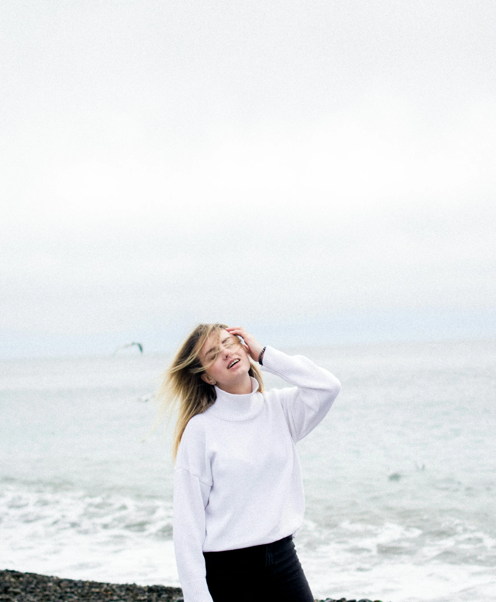 the woman is smiling by the water holding her head