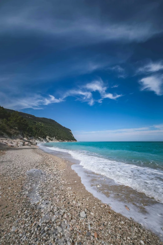 a beach area with an ocean and blue sky