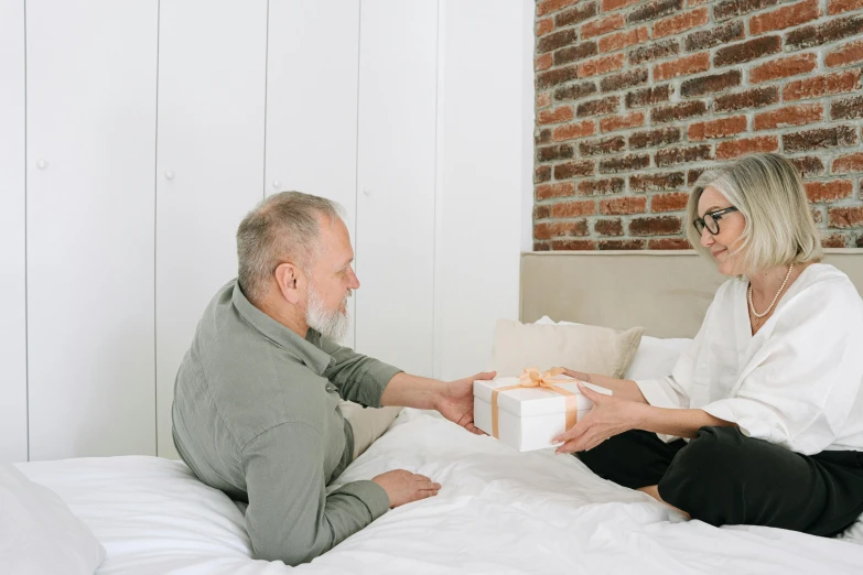 a man giving a woman soing in a gift box