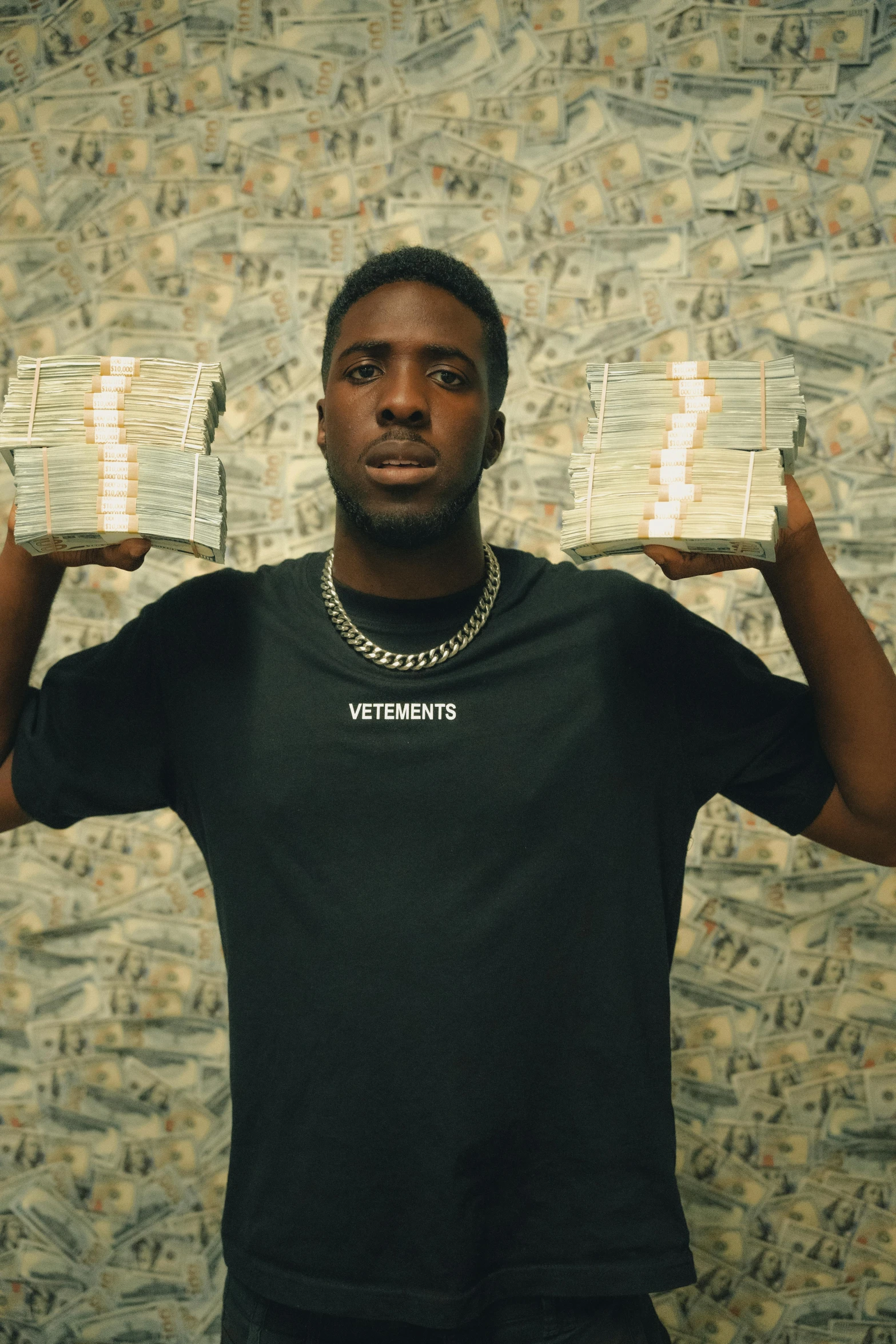 a man in a black shirt holds up newspapers on his hands