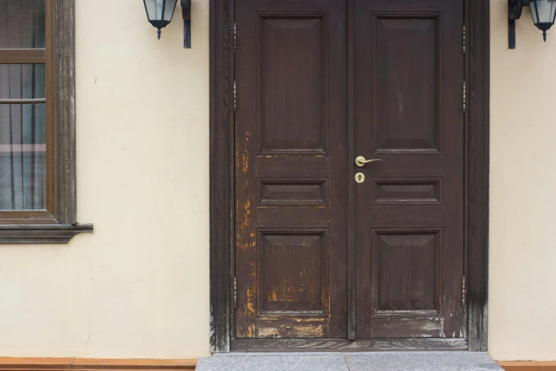 two black door on white walls with two lights