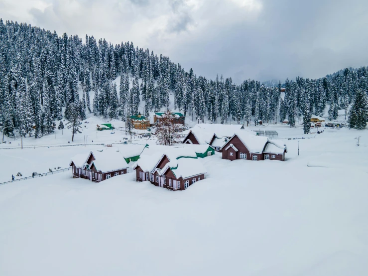 some very pretty buildings covered in snow by a mountain