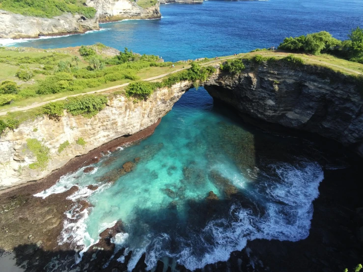 blue water is flowing out from inside of a cave