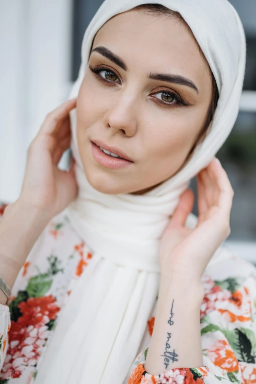 a young woman in florals is holding her hand against her ear