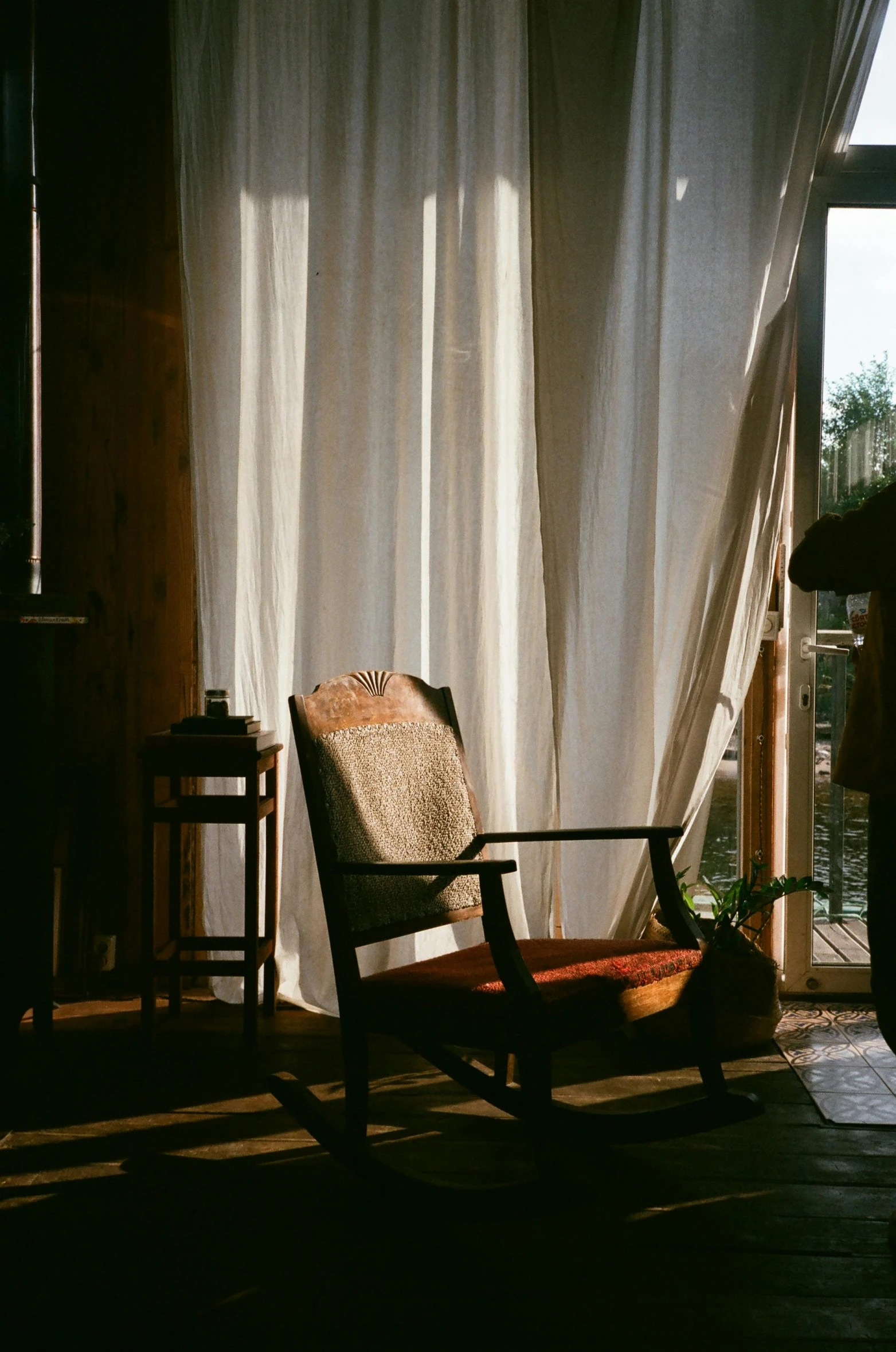 a chair next to a curtain in a small room