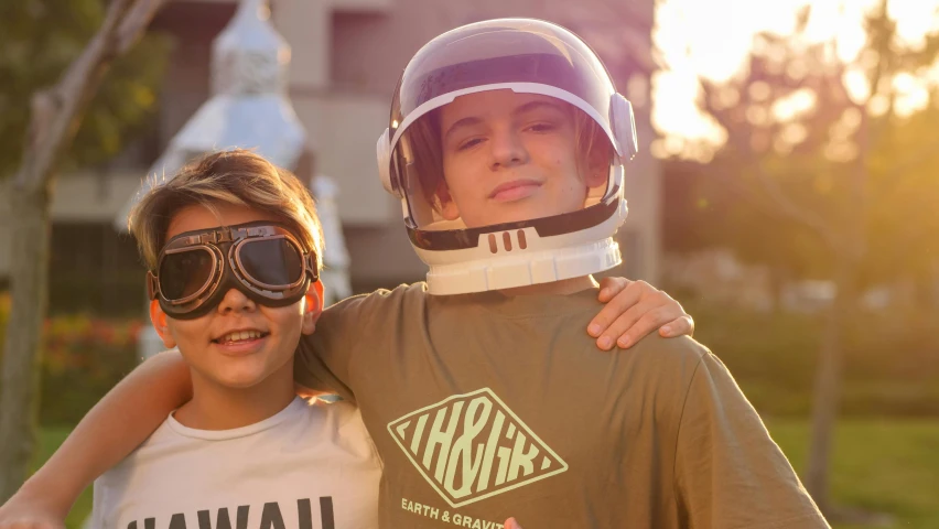 two children wearing helmets posing for the camera