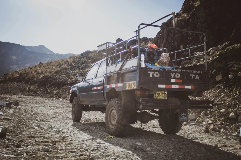 a black pick up truck driving down a rocky hill