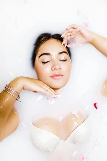 a woman wearing white sitting in a bath tub