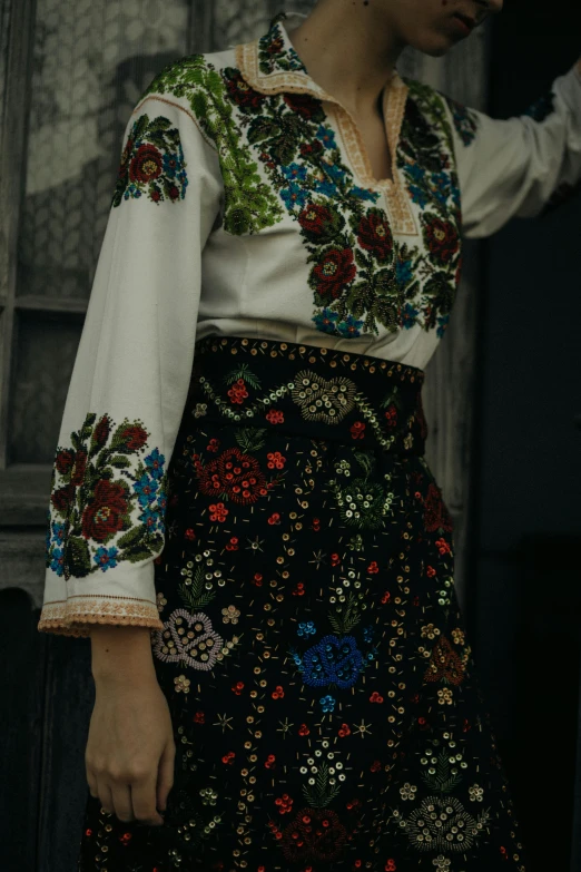 woman in a folk outfit and hat walking across a building