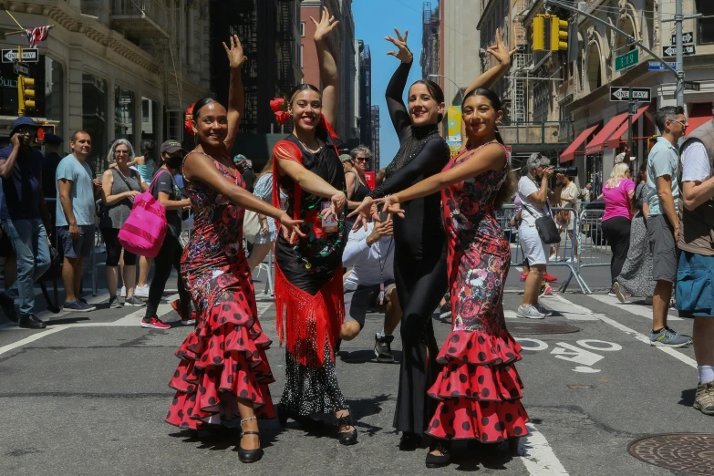 three young women dressed in flamenco dresses posing for the camera