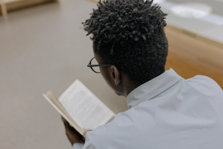 the man is looking through the book, in front of him