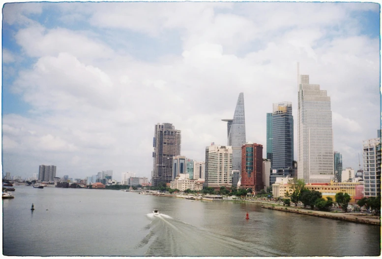 a city scene with a boat traveling on the water