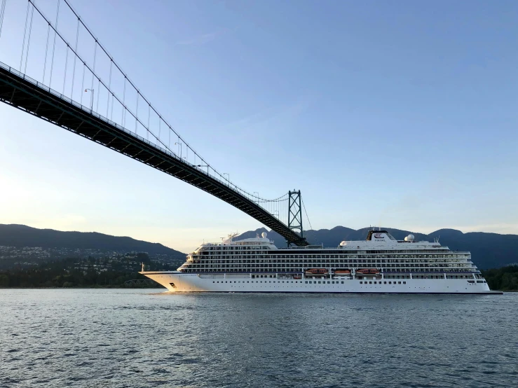 a large cruise ship under a bridge in the water