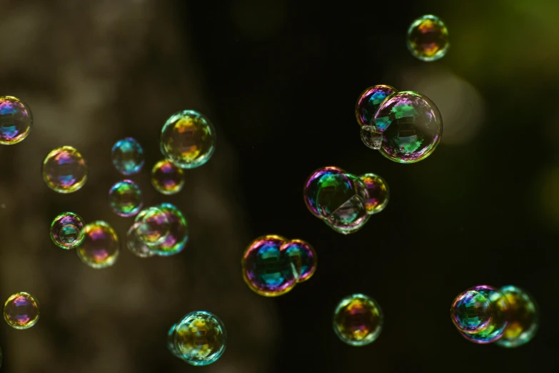several rainbow colored soap bubbles floating in the air