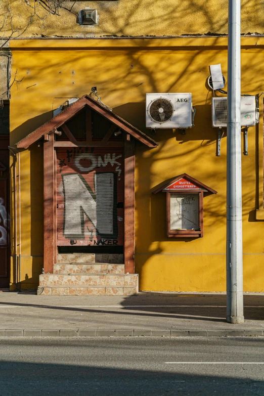 an old fashioned phone booth on a yellow building